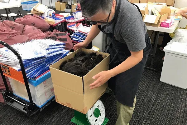 JHD&C事務局で毛髪仕分け作業をする渡辺